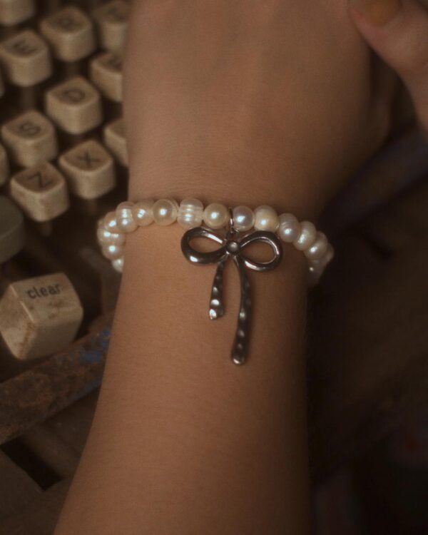 Pearl bracelet with silver bow charm